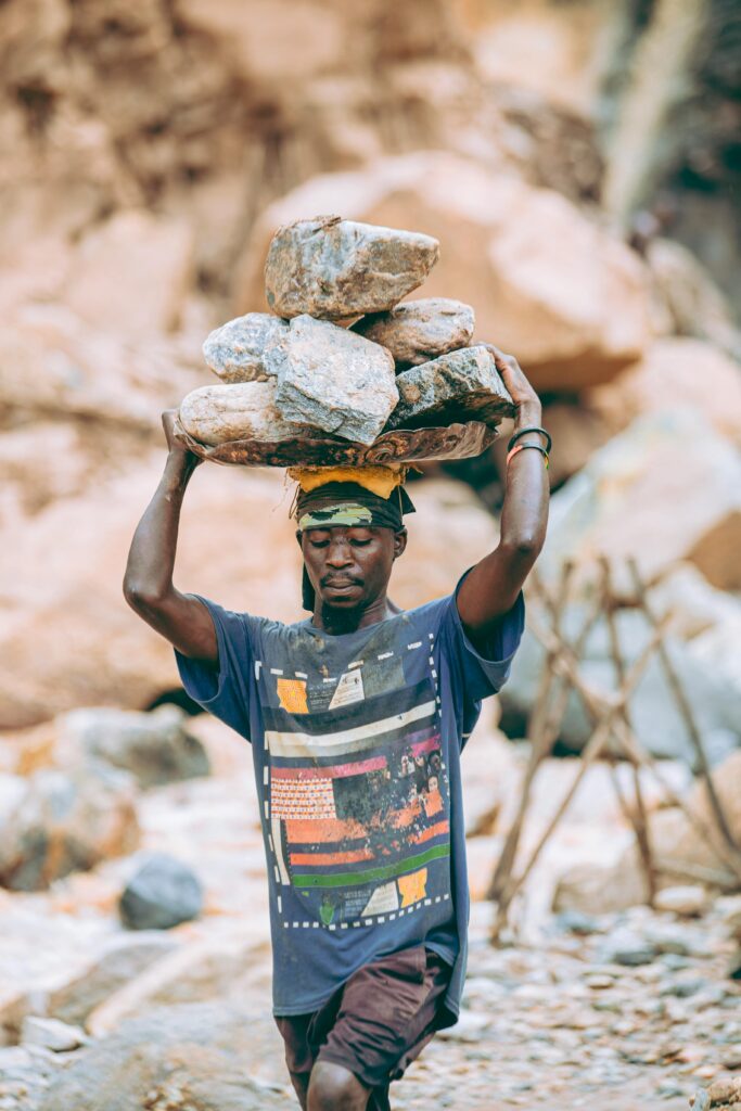 A construction worker carrying stones